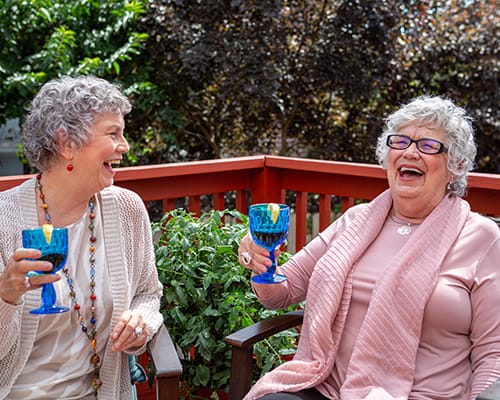 women laughing and drinking wine
