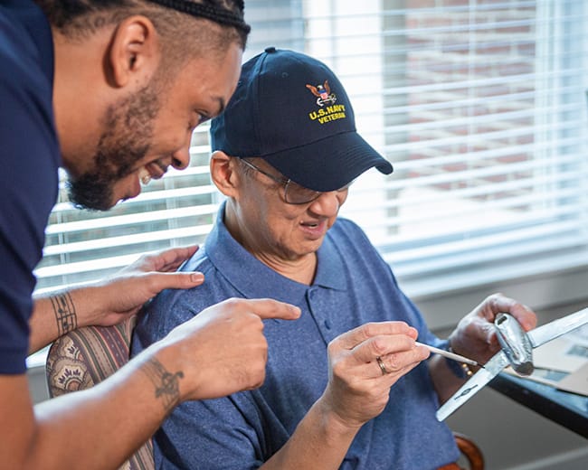 caregiver helping resident paint