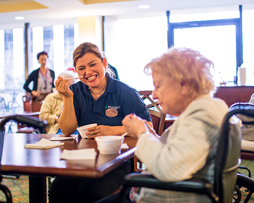 caregiver and resident eating together