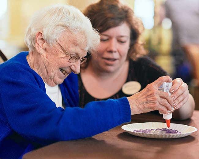 caregiver helping resident with craft