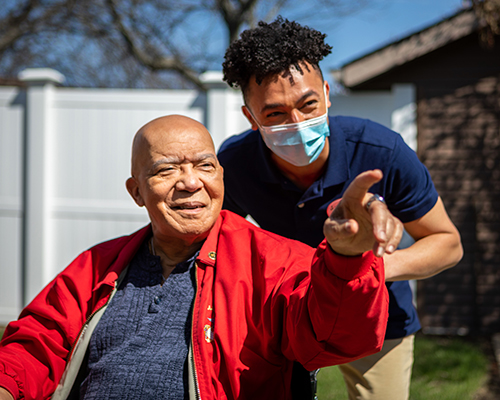 caregiver pushing resident in wheelchair
