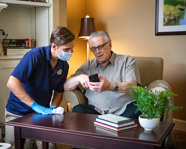 resident showing caregiver something on a phone