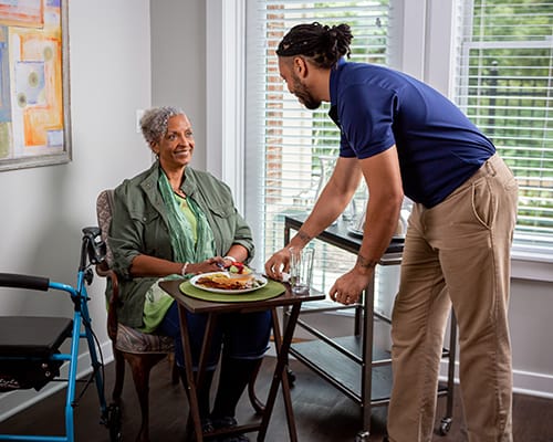 caregiver serving food to a resident