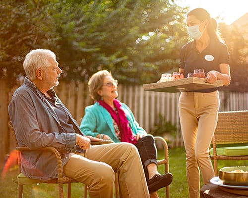 caregiver serving drinks to couple
