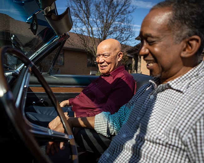 caregiver sitting in car with man