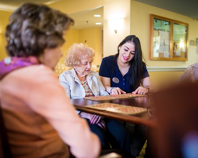 caregiver helping woman play bingo