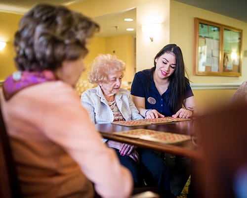 caregiver and resident playing a board game