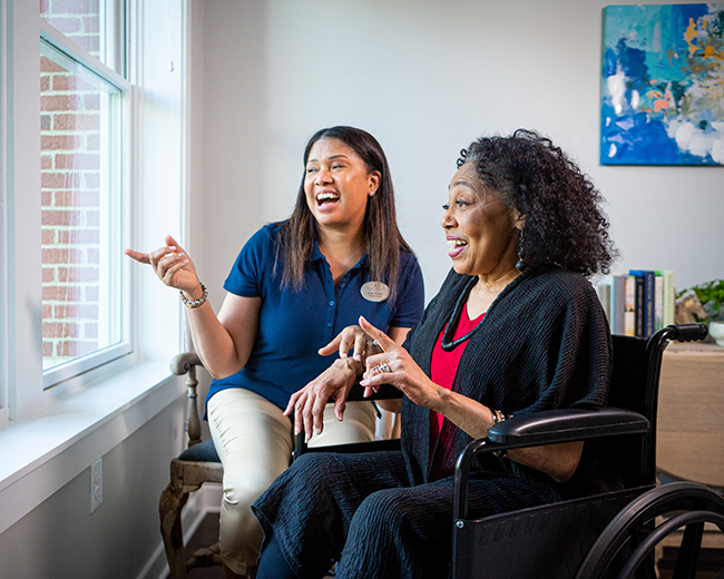 woman looking out window with caregiver