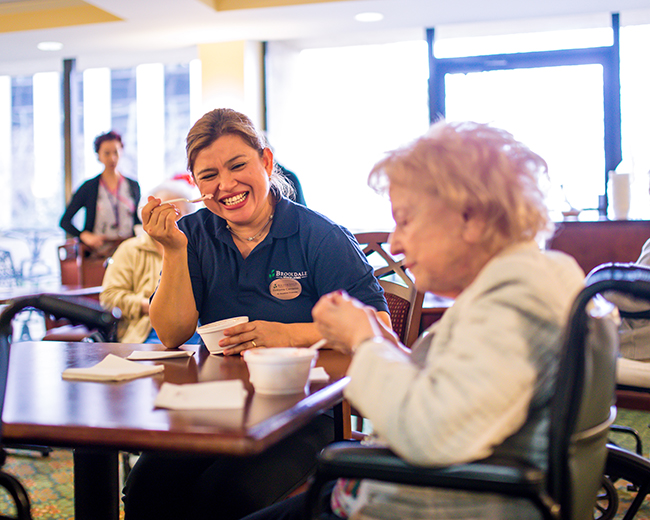 caregiver and resident eating ice cream