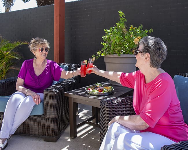 women cheers drinks outside
