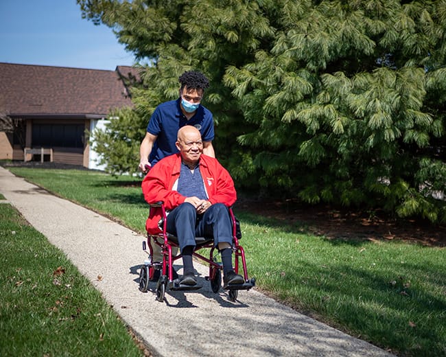 caregiver pushing resident in a wheelchair