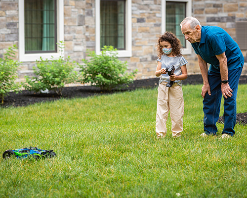 grandfather and granddaughter playing with toy car