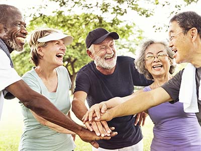 group of senior friends laughing in huddle