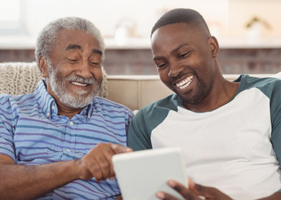 Father and son looking at mobile tablet