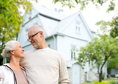 Senior couple in front of house