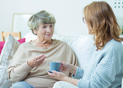 daughter having tea with elderly mother