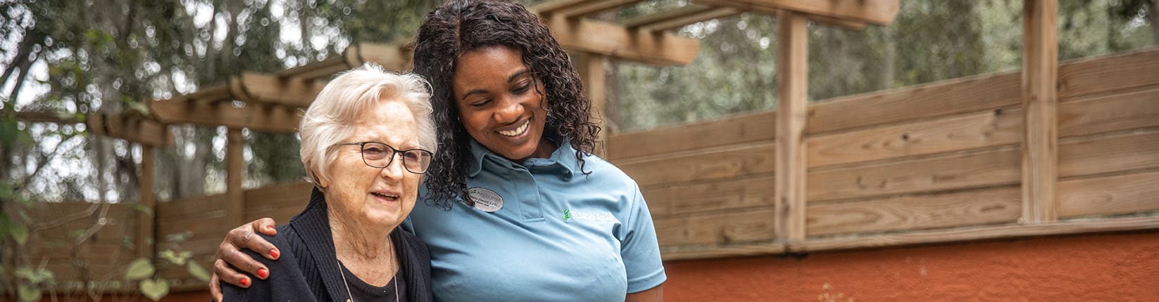 Caregiver walking with arm around resident