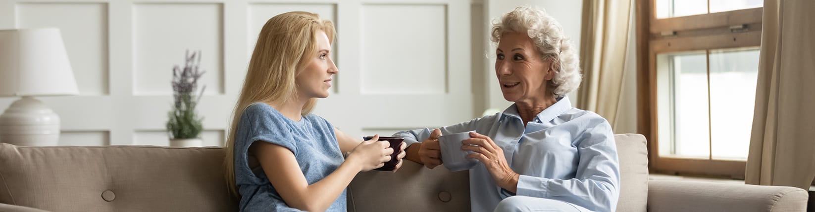 mother and daughter drinking coffee on the couch